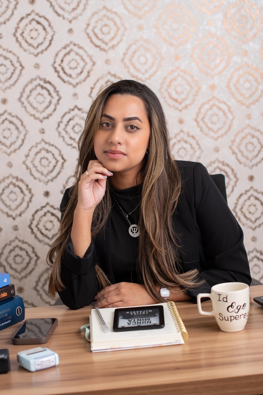 Aline Araujo sentada à mesa de trabalho